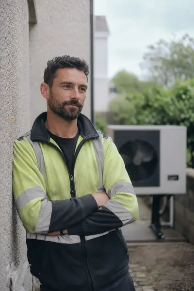 SEAI registered engineer standing beside an installed heat pump outdoor unit