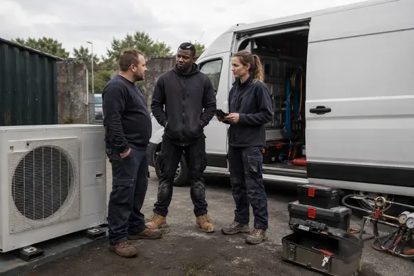 Three installers talking at the open back of a van with tool cases out, typical of the work SEAI registered installers in Wexford carry out